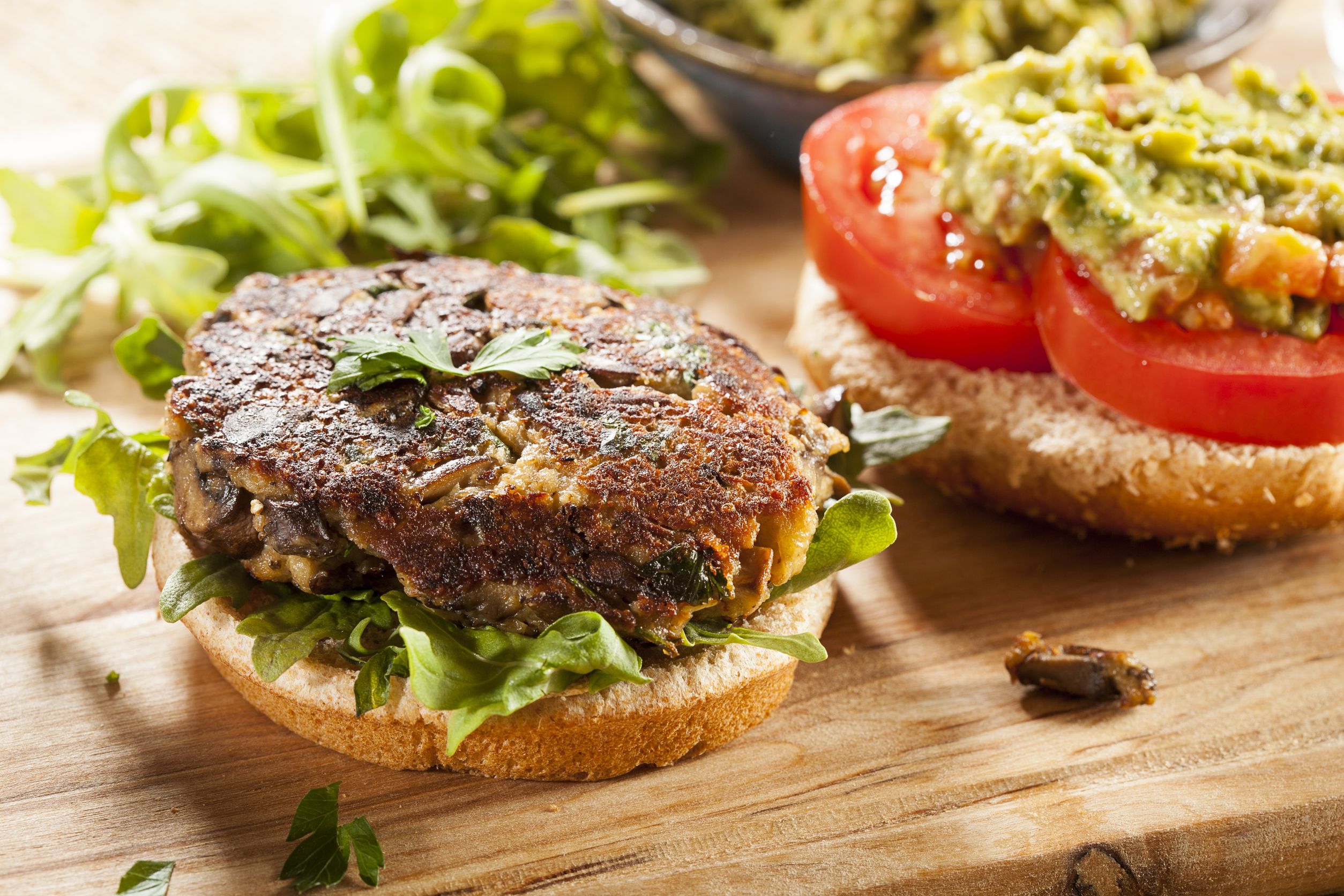 19005056 - homemade organic vegetarian mushroom burger with tomato and guacamole