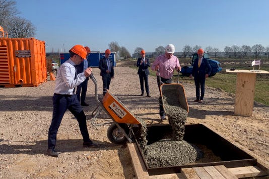 Directeur Frank Hessing en projectleider bouw Michiel Louwe Kooijmans storten het eerste beton van de nieuwe fabriek in bijzijn van gedeputeerde Van den Akker, burgemeester Palmen, wethouder Tegels en directeur van het bouwbedrijf Frank van de Ven.