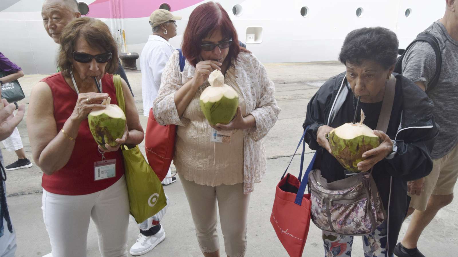 Enkele toeristen van de MV Norwegian Dawn-cruise drinken kokossap in de haven van Mombasa, Kenia. De foto is half januari genomen, toen er nog niets aan de hand was. (AP-foto/Gideon Maundu).