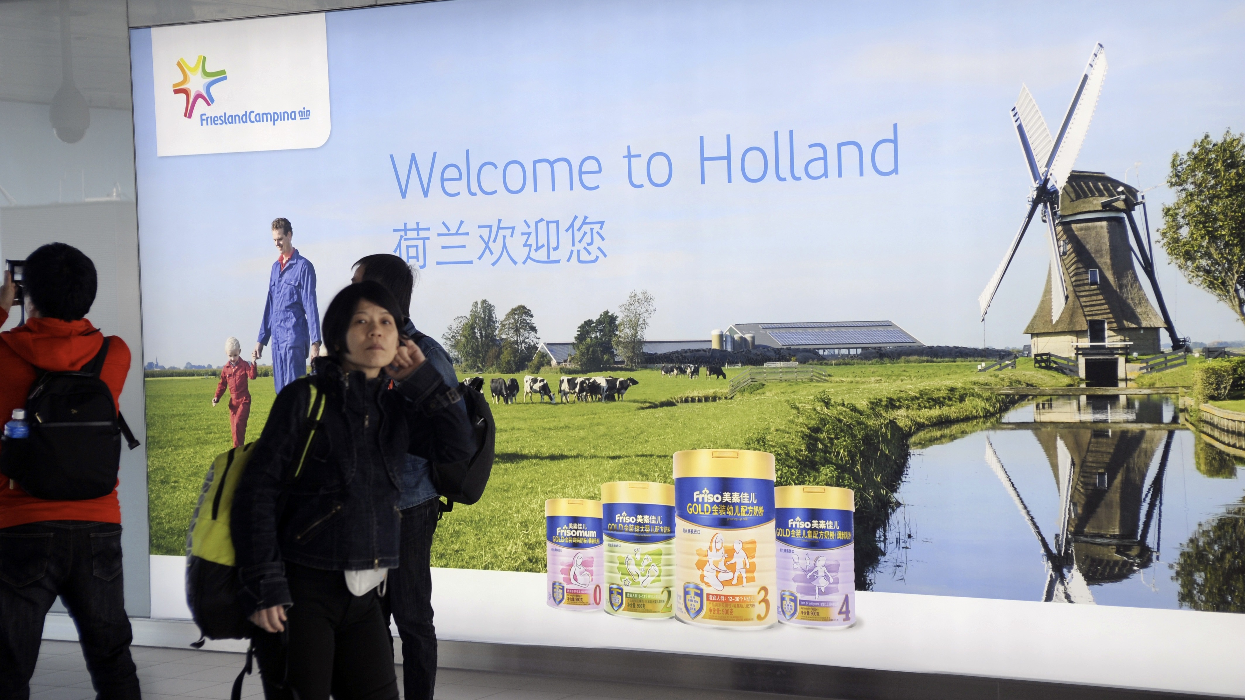 In 2017 verwelkomde FrieslandCampina aankomende passagiers uit Azie met een reclame op Schiphol. De producent exporteert veel melkproducten naar Azie. Nu raken Chinese tarieven ook FrieslandCampina. (Beeld: ANP/(c) Paul van Riel / HH)
