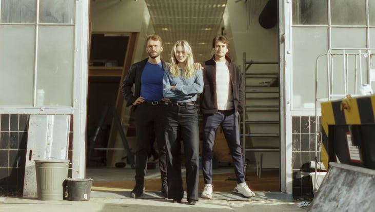 Mark de Boer van Upfront (links) in de entree van het pand dat verbouwd is tot supermarkt. Sanna Wilms (midden) Klantervaring Supermarkt en Jan van Overdam (rechts) leider Supermarkt. Foto: Upfront